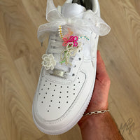 White organza ribbon shoe laces styled with colourful floral charm bouquet, pearl flower charm and lace accessories on Nike Air Force 1 trainers.