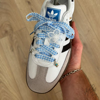 Blue gingham ribbon shoe laces with embroidered flower patch, flower charm and silver lace charms on Adidas Samba trainers.