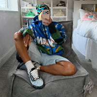 Model wearing custom Denim Bloom Vans Old Skool trainers with fluffy white laces, featuring distressed denim, floral artwork and hand-painted details.