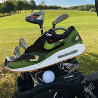 Custom Nike Air Max 1 Golf fairway camo sneaker on golf course with golf clubs, camo inspired design