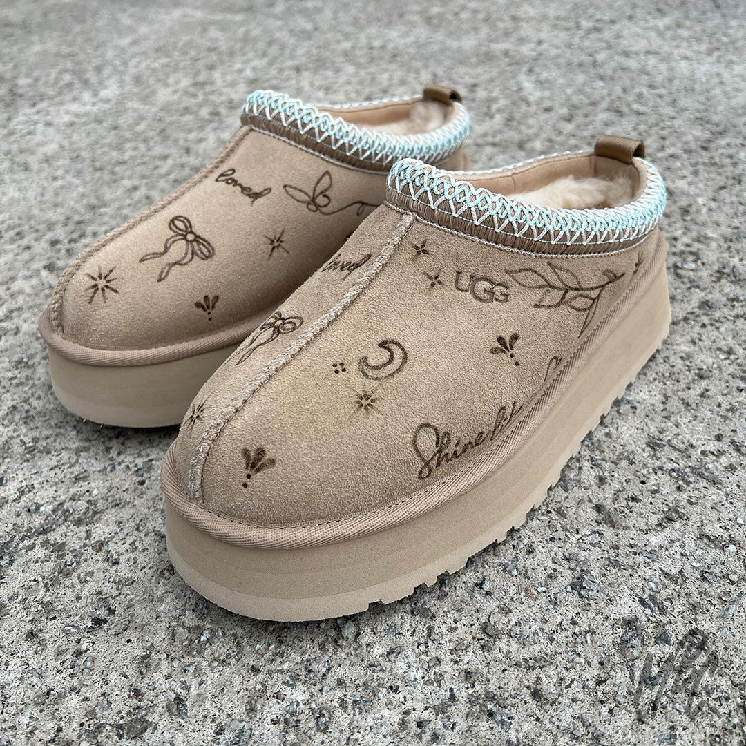 Pair of customised beige UGG Tazz II slippers with linework tattoo burnt into the suede