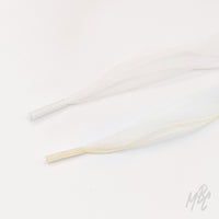 Sheer white and cream fishtail ribbon shoelaces with clear plastic aglets arranged on a white background.