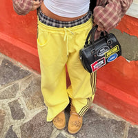 Flaming Dragon custom Timberland boots styled with yellow tracksuit and streetwear accessories outdoors