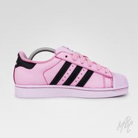 Side profile of Pink Overgrown custom Adidas Superstar in soft pink with black three stripes and matching pink laces.