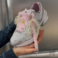 White and pink ASICS trainers with fluffy pink shoelaces, pearl lace charms, flower lace charms and decorative sneaker accessories