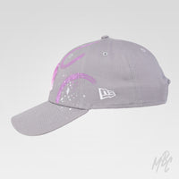 Side view of the Gradient Swipe custom New Era NY cap with abstract pink and purple hand-painted swipes and white paint splatter details.