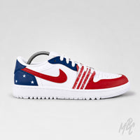 A Nike Air Jordan 1 sneaker in a patriotic red, white, and blue colorway. The shoe features a white leather base with a red Swoosh, red toe cap, red textured stripes, a blue heel tab with white stars, and white laces, displayed on a neutral light gray background.