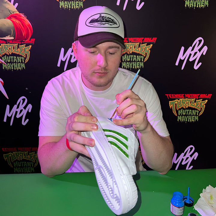 An artist creating custom adidas superstar TMNT shoes for the Teenage Mutant Ninja Turtles: Mutant Mayhem premiere