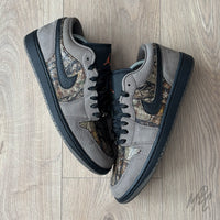 Woodland Camo Jordan 1 Low flat lay pair showing brown suede overlays and camo underlays