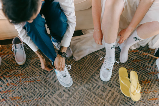 Bride and groom putting on their custom Nike sneakers at their wedding