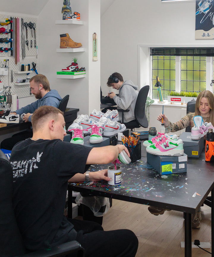 MattB Customs Workshop or office space with people working on trainer projects, surrounded by tools and materials.
