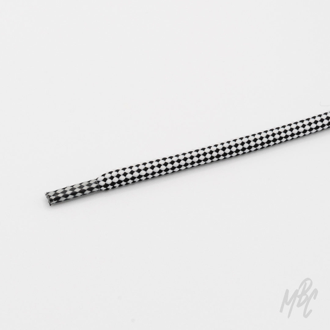 Close-up of a round black-and-white checkered technical shoelace with a matching patterned aglet on a white background.