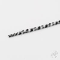 Close-up of a round black-and-white checkered technical shoelace with a matching patterned aglet on a white background.