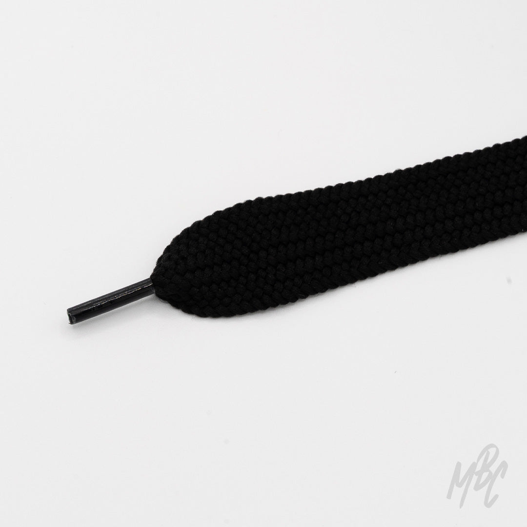 Close-up of a wide black shoelace with a thick woven texture and matching black plastic aglet on a white background.