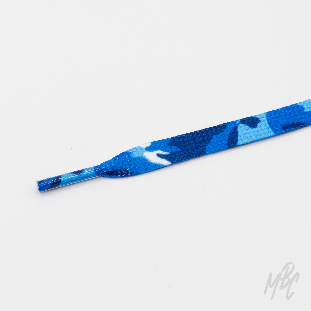 Close-up of a flat blue camouflage shoelace with a matching patterned aglet on a white background.
