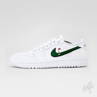 Side profile of an all-white Air Jordan 1 Low Golf shoe with a green, black-outlined Nike Swoosh featuring a red golf flag and hole design.