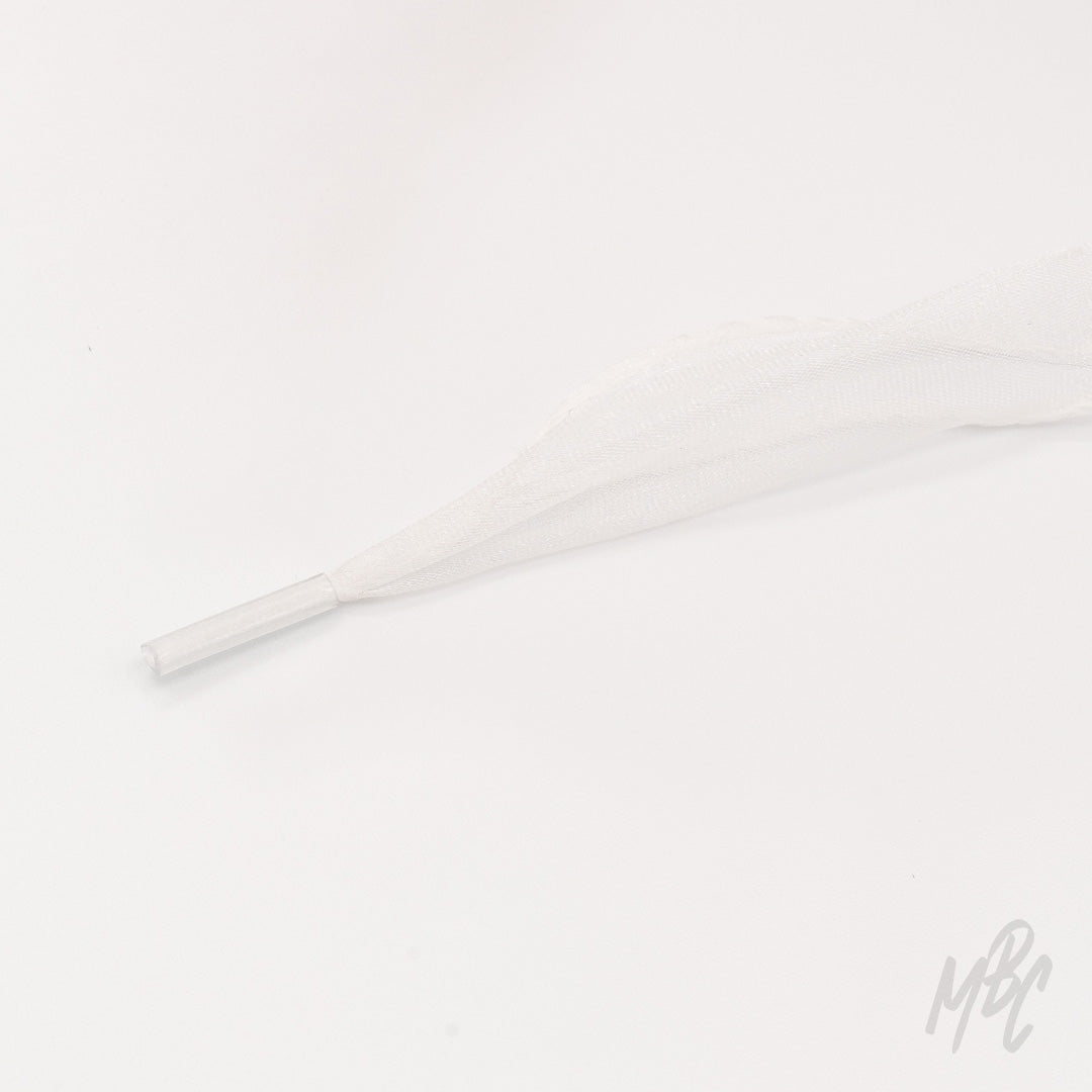 Close-up of a sheer white fishtail ribbon shoelace with a clear plastic aglet on a white background.