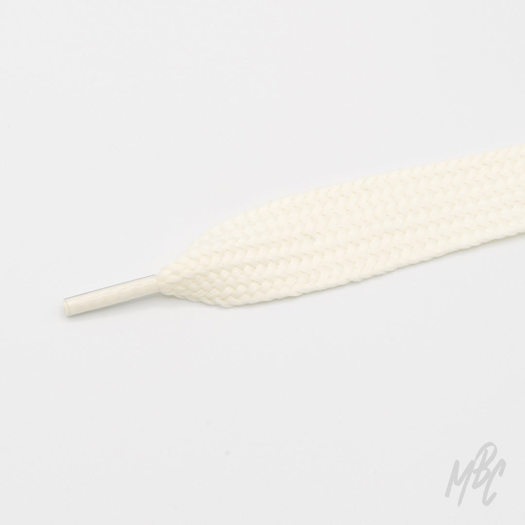 Close-up of a wide cream shoelace with a thick woven texture and matching plastic aglet on a white background.