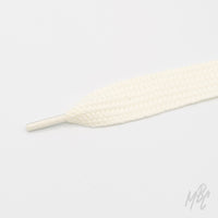 Close-up of a wide cream shoelace with a thick woven texture and matching plastic aglet on a white background.