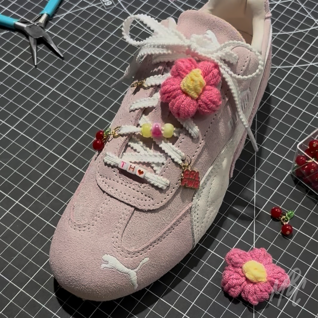 Pink Puma trainers personalised with decorative lace charms, flower lace accessories, cherry charms and custom white trainer laces