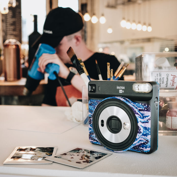 hand painting polaroid cameras and film at a fujifilm pop up