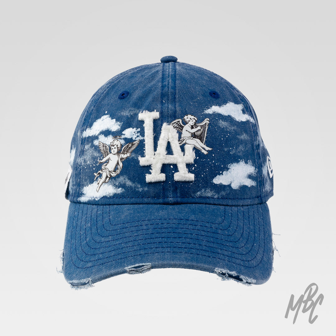 Denim Heaven New Era NY custom cap in blue denim with cherub angel illustrations, hand painted clouds and distressed brim