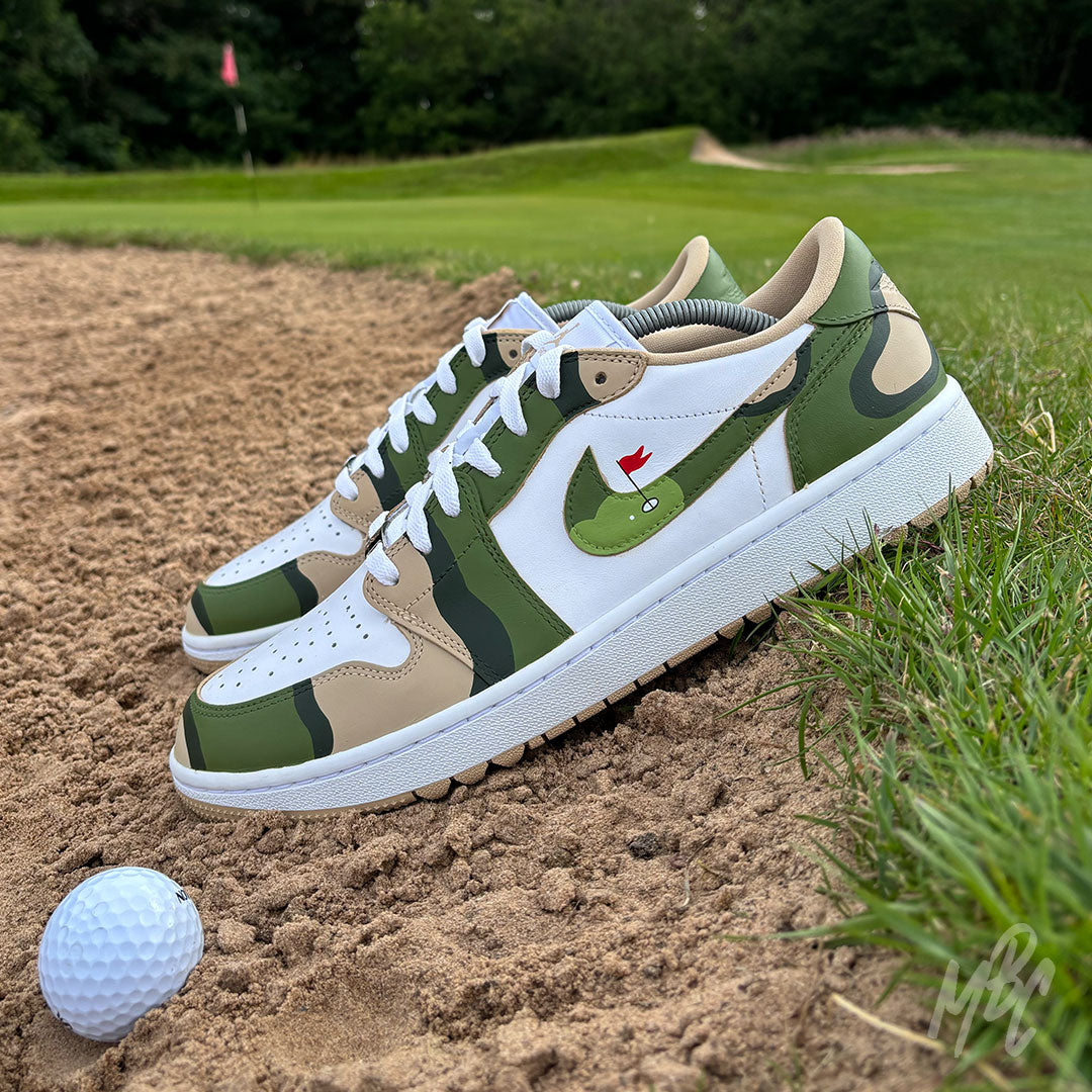 Fairway Camo Jordan 1 Low Golf custom golf shoes positioned in a bunker beside a golf ball on the course