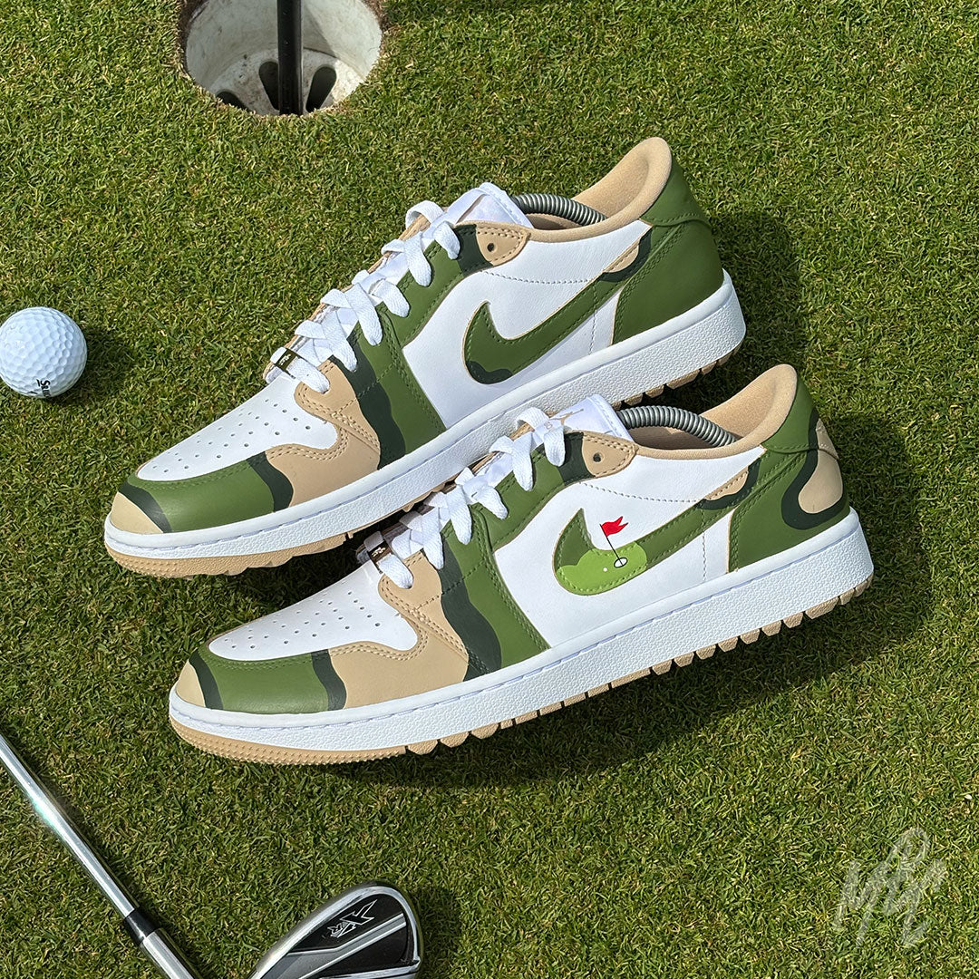 Custom Fairway Camo Jordan 1 Low Golf trainers on the putting green beside a golf hole and golf club