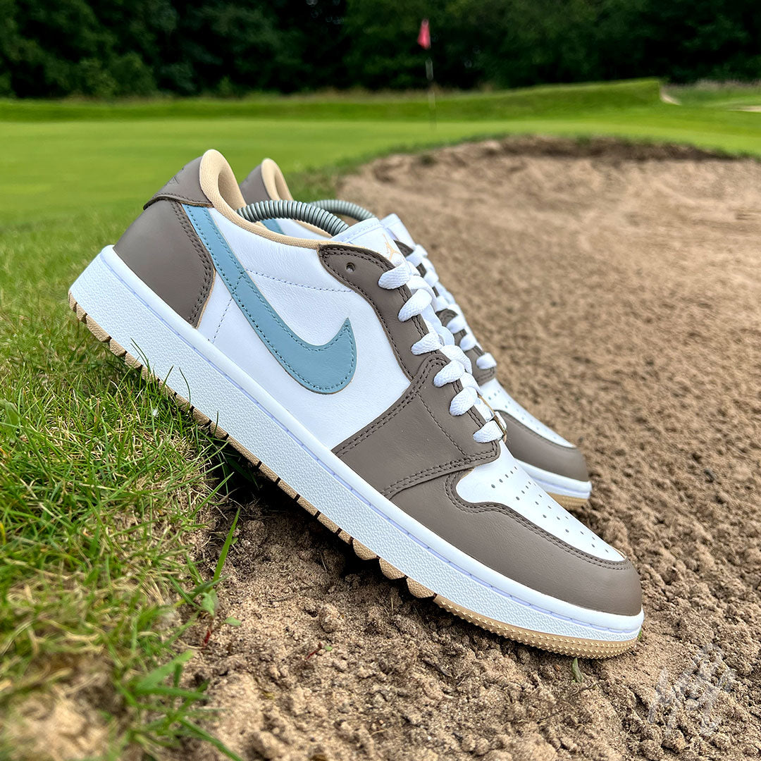 Fairway Fog Jordan 1 Low Golf custom golf shoes positioned beside a bunker on a golf course fairway