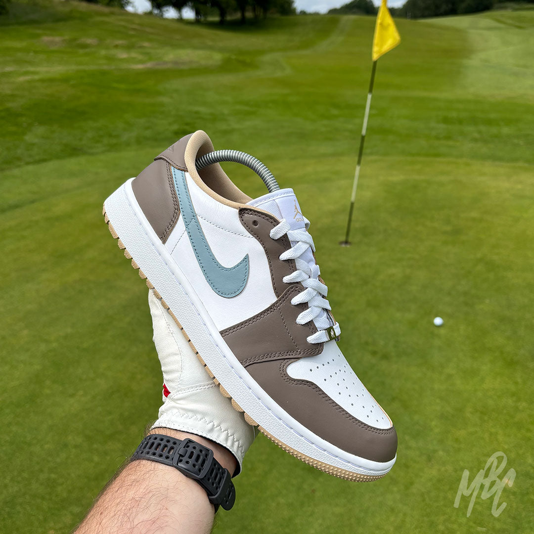 Fairway Fog Jordan 1 Low Golf custom golf shoe photographed on the green with flagstick and golf ball in the background