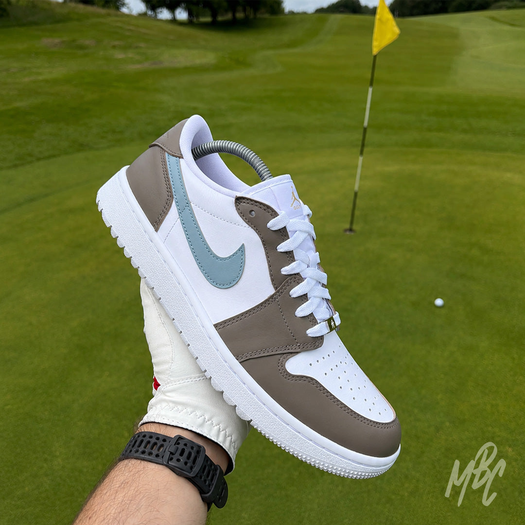 Fairway Fog Jordan 1 Low Golf custom golf shoe photographed on the green with flagstick and golf ball in the background