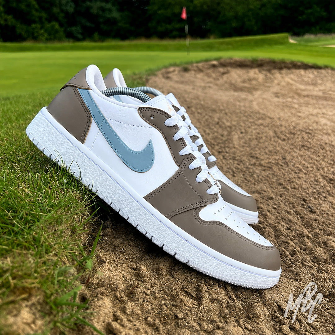 Fairway Fog Jordan 1 Low Golf custom golf shoes positioned beside a bunker on a golf course fairway