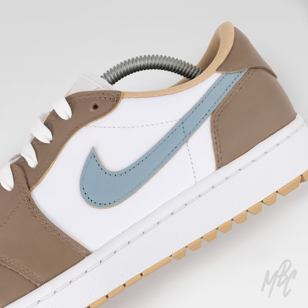 Close-up detail of Fairway Fog Jordan 1 Low Golf custom golf shoe featuring taupe leather overlays, white leather upper and light blue Swoosh