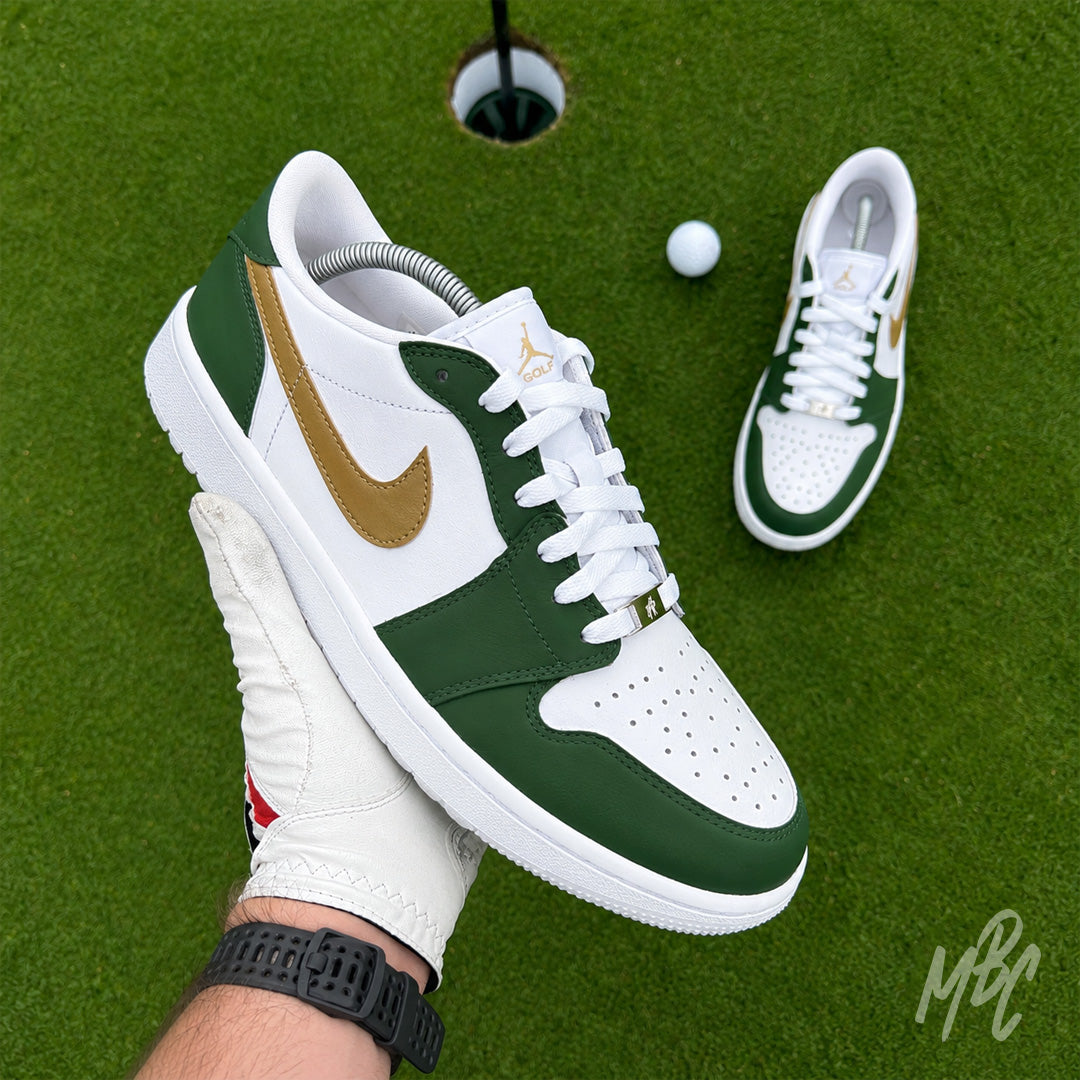 Fairway Gold custom Jordan 1 Low Golf shoes with hand-painted green and gold leather panels, photographed on a putting green.