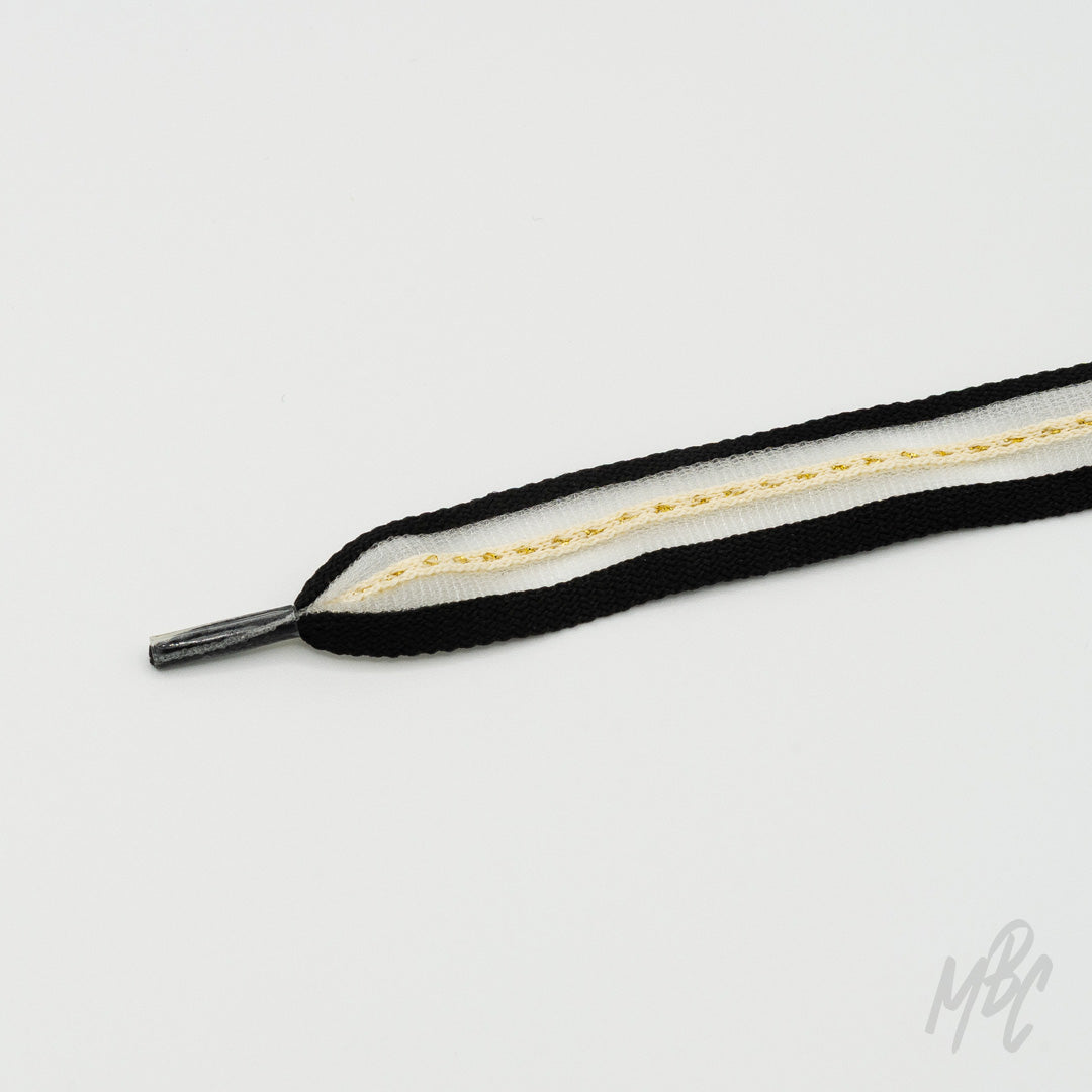 Black and white sneaker laces featuring gold stripe detailing and layered woven construction for custom trainers