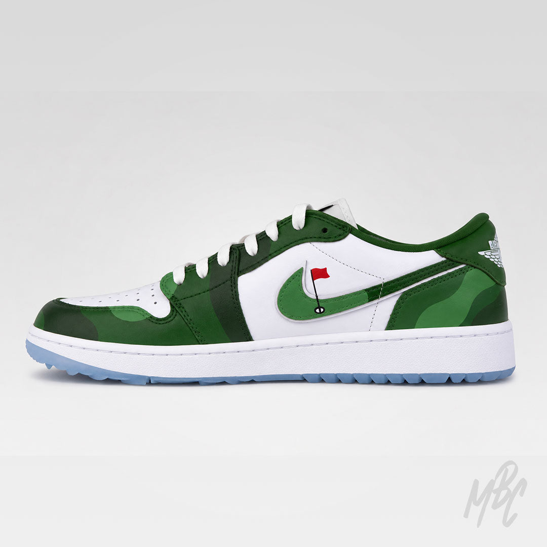 A low-top Nike sneaker in green and white, featuring a green camouflage pattern on the toe and heel, a white side panel with a green swoosh, a small red flag graphic on the swoosh, and a light blue outsole.