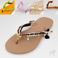 customised Havaianas flip-flops with colourful braided straps and charms, centred around a brown pair with neutral braiding and gold details.