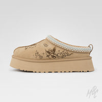 Side profile of the Heaven Etched UGG Tazz II custom featuring tattoo-inspired cherub artwork engraved into suede