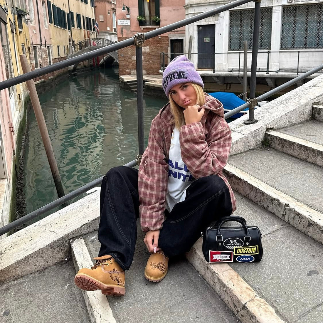 Flaming Dragon custom Timberland boots with hand-engraved dragon artwork worn by fashion influencer in Venice canal street setting