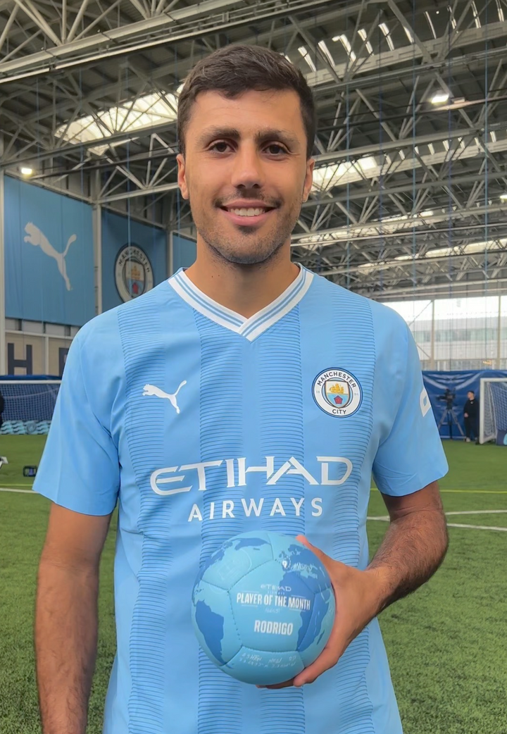 Rodrigo holding his Manchester City Player of the Month custom football