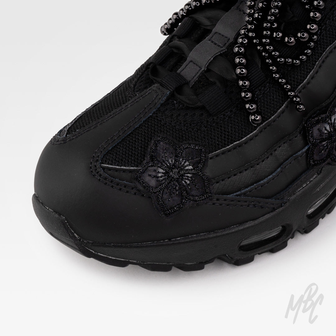 Close-up of Midnight Veil custom Nike Air Max 95 featuring black floral embroidery, satin ribbon laces and black beaded bow charm.