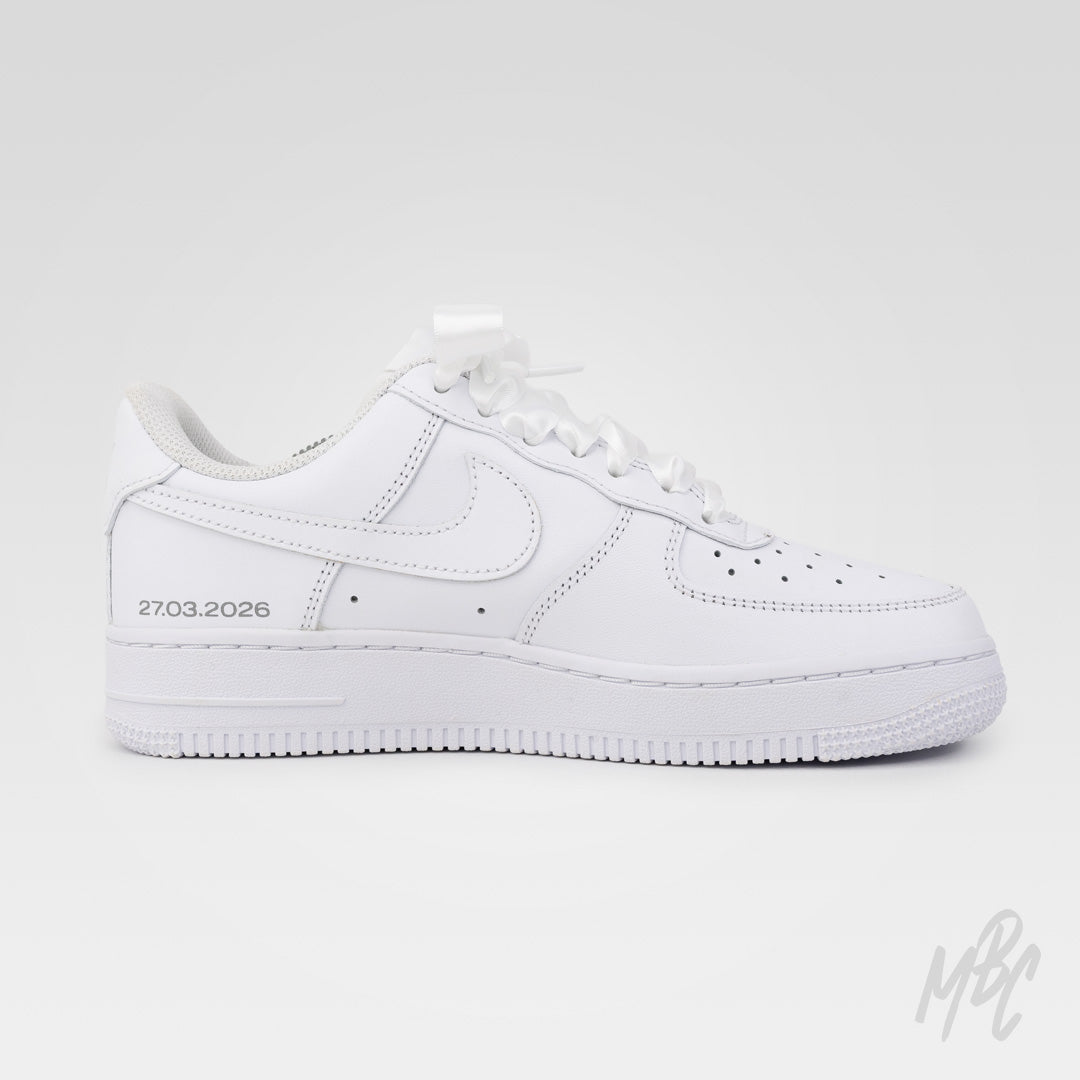 Studio image of white Nike Air Force 1 custom featuring lace material and pearl embellishments