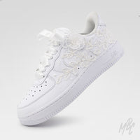 Angled view of white Air Force 1 custom with lace detailing, satin ribbon laces and white sole