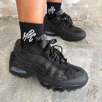 Close-up of the Midnight Veil custom Nike Air Max 95 on foot, highlighting black floral appliqués, satin ribbon laces, black beaded laces and premium all-black detailing.