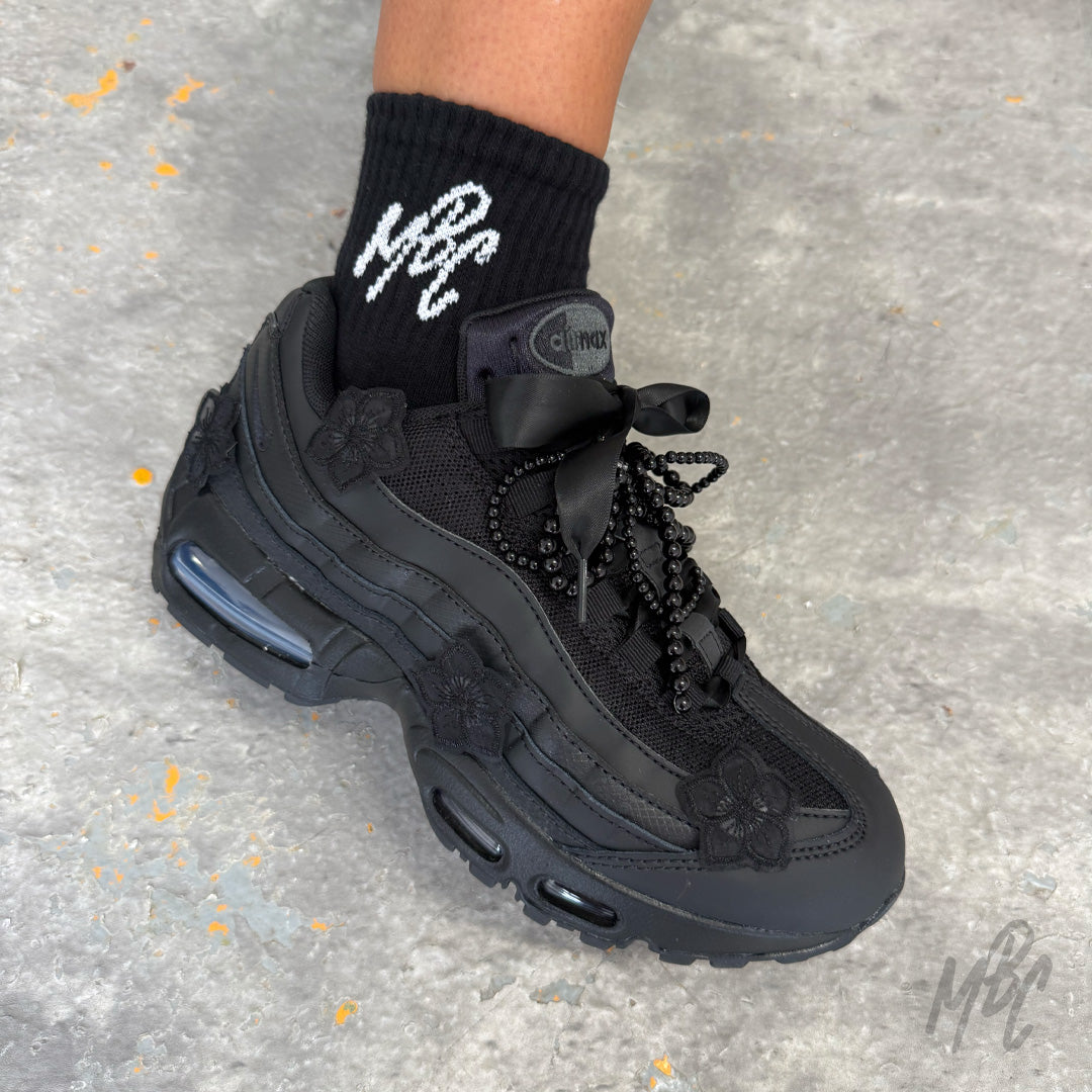 Side profile of the Midnight Veil custom Nike Air Max 95 showcasing black floral appliqués, satin ribbon laces, decorative black bead laces and a monochrome black design.