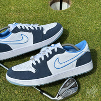 Navy Suede Jordan 1 Low Golf custom golf shoes displayed on a putting green with golf club and hole cup