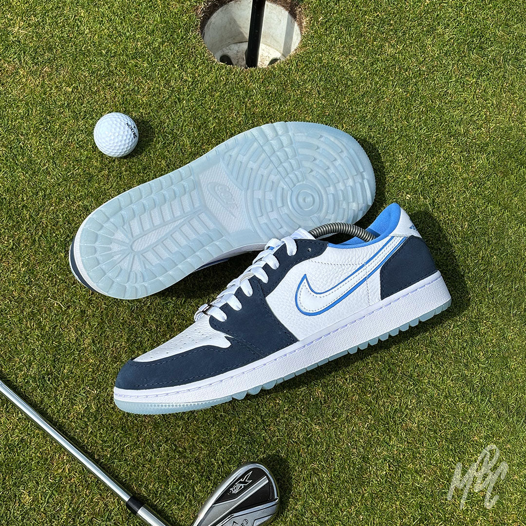 Navy Suede Jordan 1 Low Golf custom golf trainers on a putting green showing outsole traction beside a golf ball