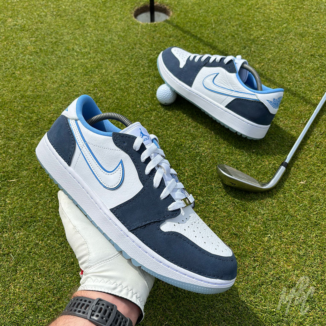 Navy Suede Jordan 1 Low Golf custom golf shoe photographed on a putting green with golf ball and iron club