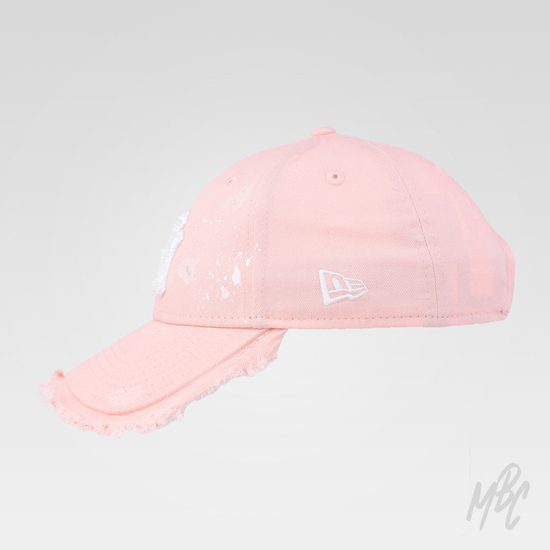 Side view of the Pink Raw Edge custom New Era NY cap with distressed frayed brim, hand-painted white paint splatters and vintage worn finish.