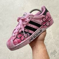 Side profile of the Pink Overgrown custom Adidas Superstar with hand-painted pink floral artwork, expressive brushstroke detailing, black stripes and hand-painted "Overgrown" text on the midsole.
